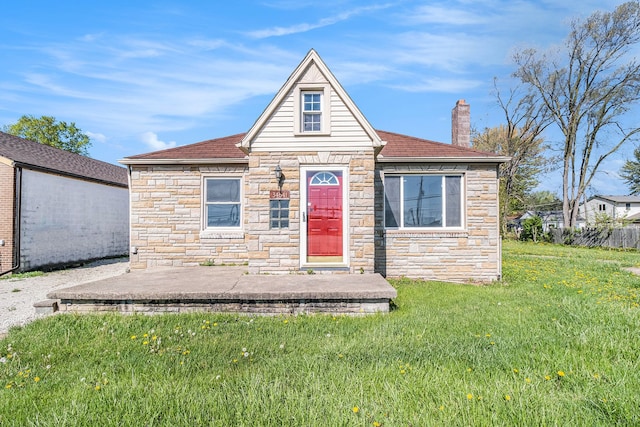 34641 Mound Rd, Sterling Heights, MI 48310 - view of front facade featuring stone siding, a chimney, a front lawn, and roof with shingles