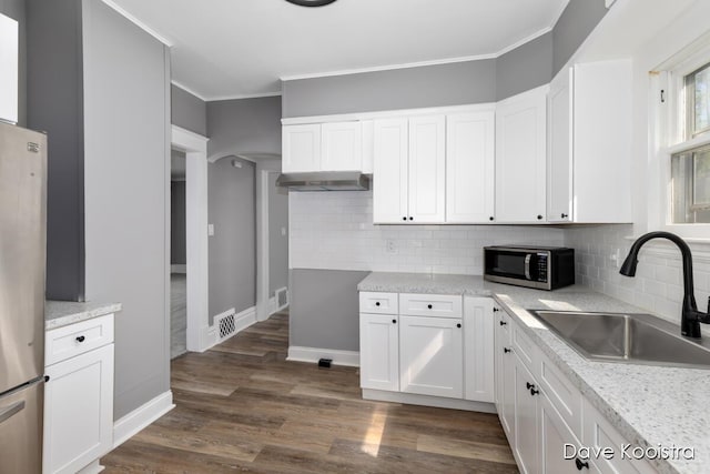 106 Colfax St NE, Grand Rapids, MI 49505 - kitchen with stainless steel appliances, a sink, white cabinetry, backsplash, and ornamental molding