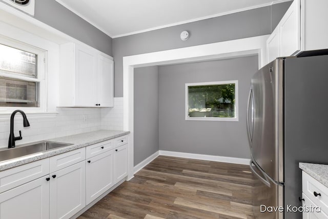 106 Colfax St NE, Grand Rapids, MI 49505 - kitchen with freestanding refrigerator, a sink, white cabinetry, decorative backsplash, and dark wood-type flooring