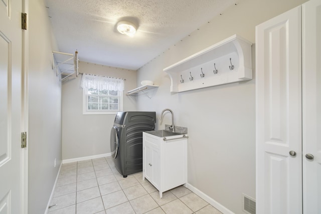 1972 Pine Ridge Dr, Manistee, MI 49660 - washroom featuring washer / dryer, baseboards, light tile patterned flooring, a textured ceiling, and a sink