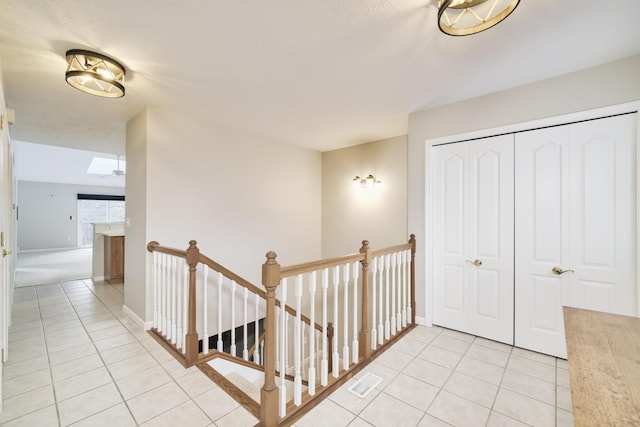 1972 Pine Ridge Dr, Manistee, MI 49660 - hall featuring light tile patterned floors, an upstairs landing, and baseboards