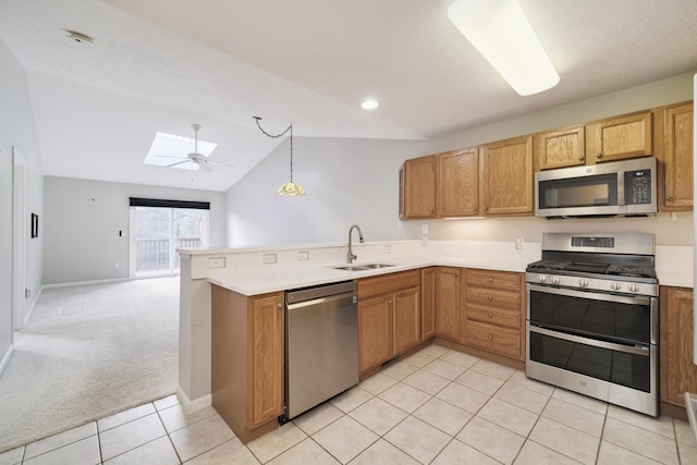 1972 Pine Ridge Dr, Manistee, MI 49660 - kitchen with stainless steel appliances, a sink, open floor plan, a skylight, and a peninsula