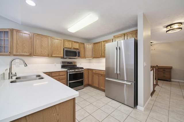 1972 Pine Ridge Dr, Manistee, MI 49660 - kitchen featuring appliances with stainless steel finishes, a sink, light tile patterned floors, and light countertops