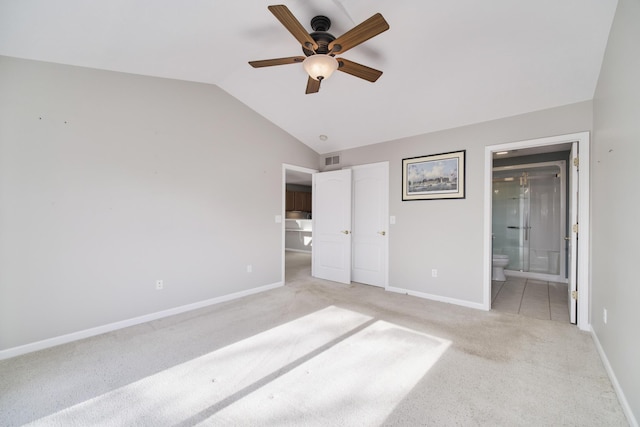 1972 Pine Ridge Dr, Manistee, MI 49660 - unfurnished bedroom featuring vaulted ceiling, light colored carpet, baseboards, ensuite bath, and a ceiling fan