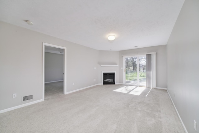 1972 Pine Ridge Dr, Manistee, MI 49660 - unfurnished living room featuring a glass covered fireplace, carpet, and baseboards