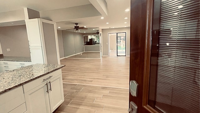 corridor featuring recessed lighting, light wood-style floors, and baseboards