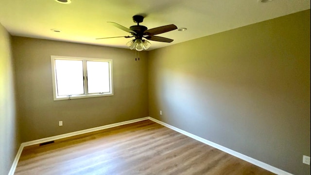 empty room with ceiling fan, wood finished floors, baseboards, and recessed lighting
