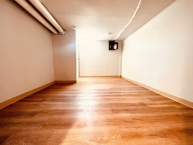 finished basement featuring light wood-style flooring and baseboards