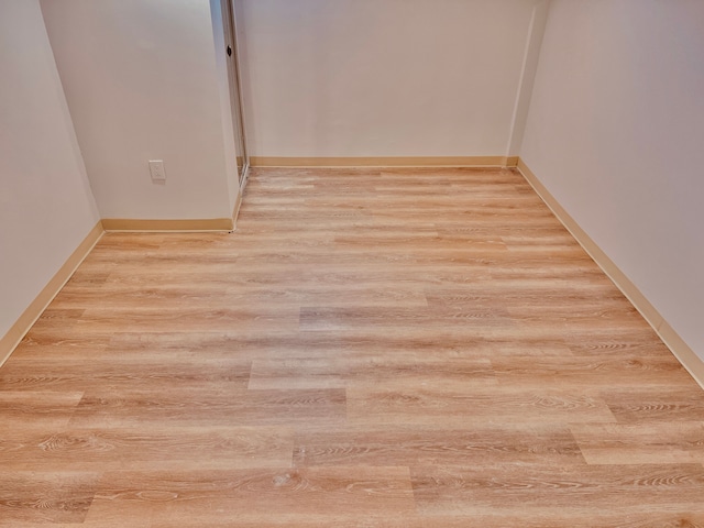 spare room featuring light wood-style floors and baseboards