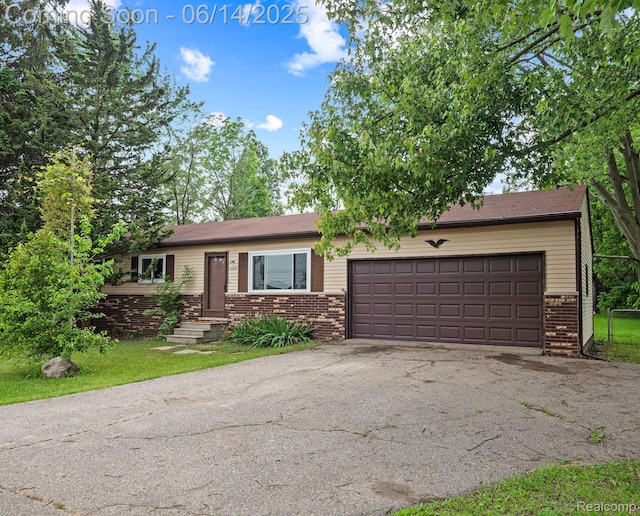 43667 Dequindre Rd, Troy, MI 48085 - view of front of home with brick siding, asphalt driveway, and a garage