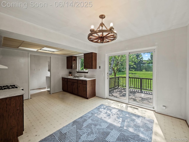 43667 Dequindre Rd, Troy, MI 48085 - kitchen featuring light floors, dark brown cabinetry, light countertops, and a chandelier