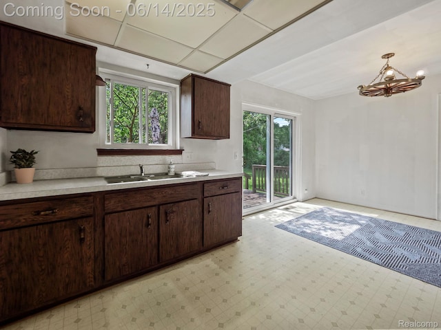 43667 Dequindre Rd, Troy, MI 48085 - kitchen featuring light countertops, light floors, a chandelier, and dark brown cabinetry