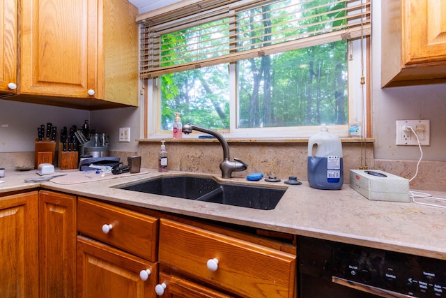 21964 Sunrise Blvd, Novi, MI 48375 - kitchen with a sink, black dishwasher, light stone counters, and brown cabinets