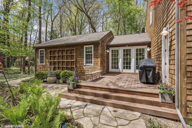back of house featuring a wooden deck and a shingled roof