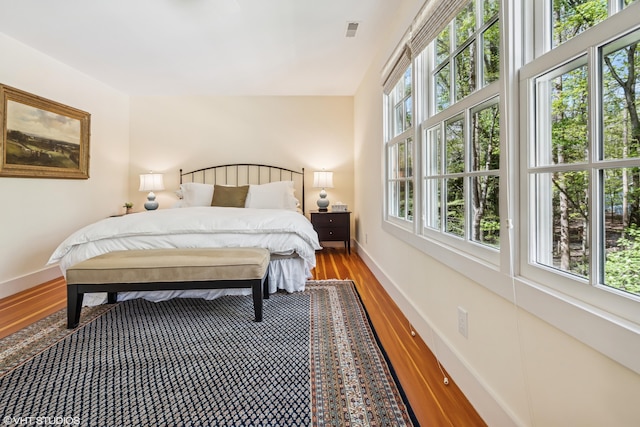 bedroom with wood finished floors and baseboards