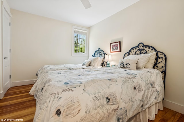 bedroom with baseboards, wood finished floors, and a ceiling fan