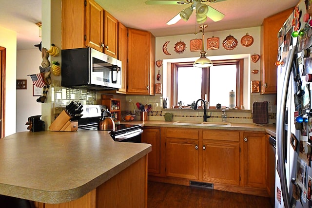 4930 Warrington Way, Gladwin, MI 48624 - kitchen with stainless steel microwave, range with electric stovetop, a sink, a peninsula, and ceiling fan