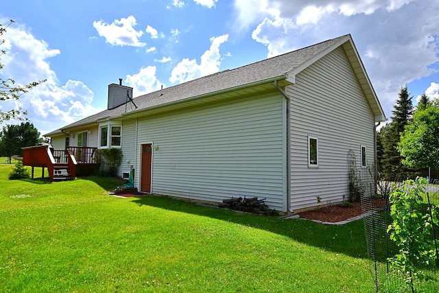 4930 Warrington Way, Gladwin, MI 48624 - view of home's exterior featuring a deck, a lawn, and a chimney