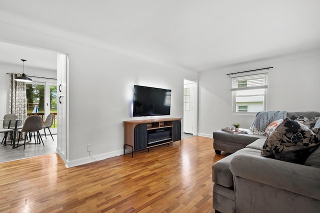 living room with plenty of natural light, light wood-style flooring, and baseboards