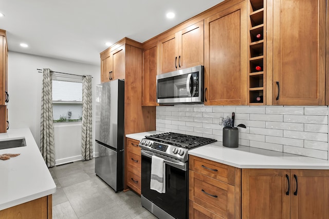 kitchen with appliances with stainless steel finishes, decorative backsplash, brown cabinetry, light countertops, and recessed lighting