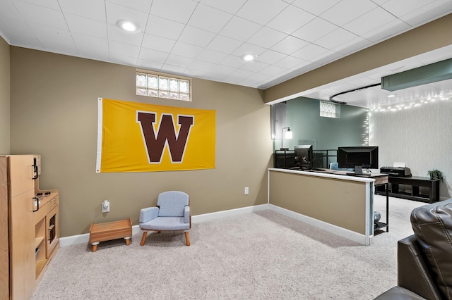 sitting room with a desk, carpet floors, and baseboards
