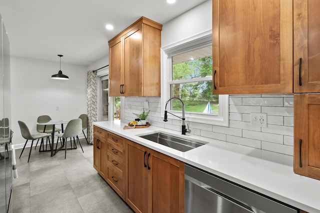 kitchen with a sink, stainless steel dishwasher, decorative backsplash, light countertops, and recessed lighting