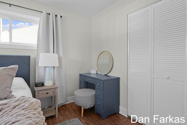 bedroom featuring dark wood-style flooring, a closet, and baseboards