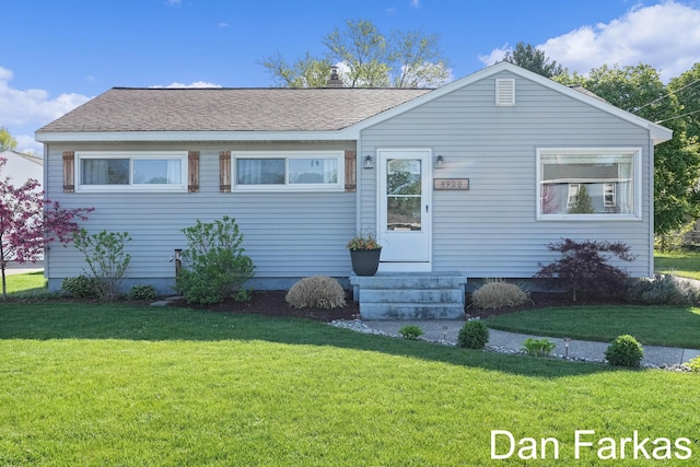 back of house with a lawn and entry steps