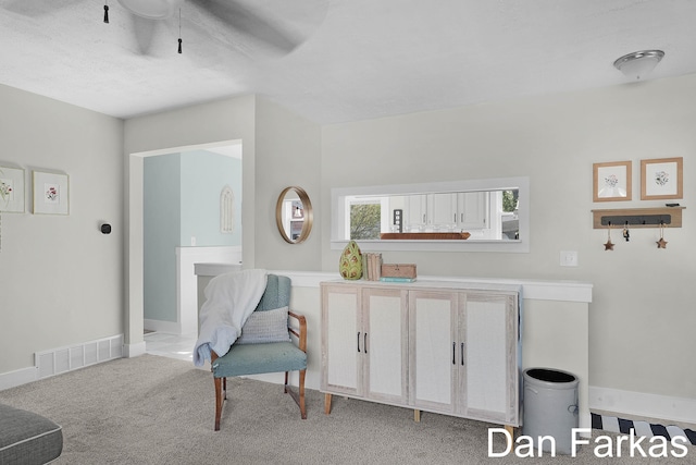 living area with ceiling fan, carpet flooring, and baseboards