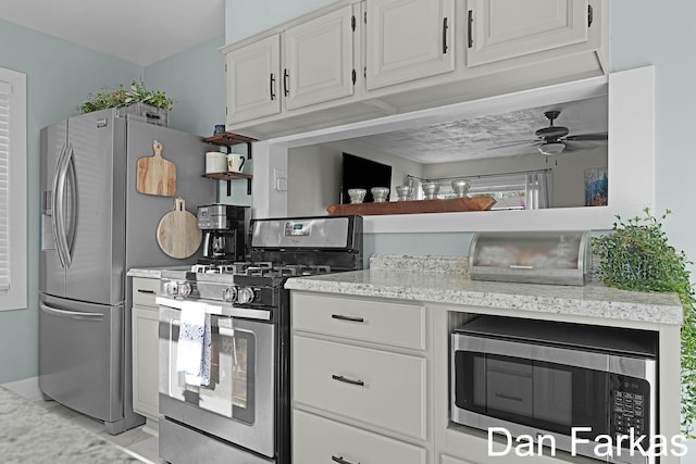 kitchen featuring stainless steel appliances, ceiling fan, and white cabinetry