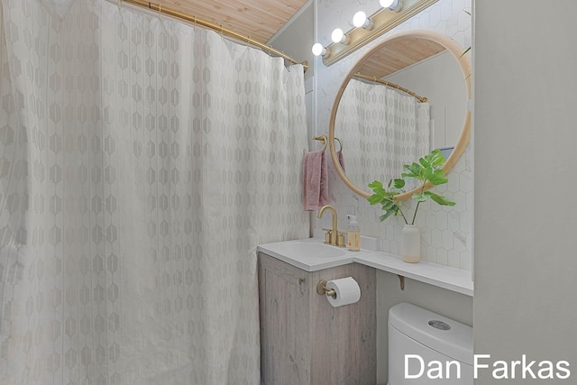 bathroom with toilet, vanity, and a shower with curtain