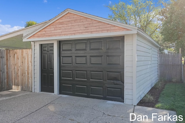 detached garage featuring fence