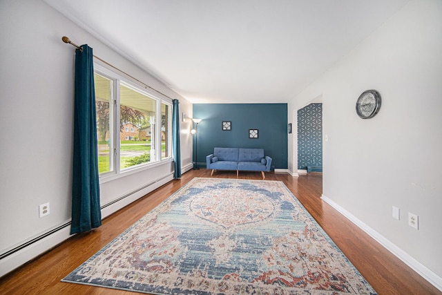 sitting room featuring wood finished floors, a baseboard radiator, and baseboards