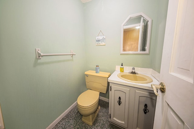 bathroom featuring toilet, vanity, tile patterned floors, and baseboards