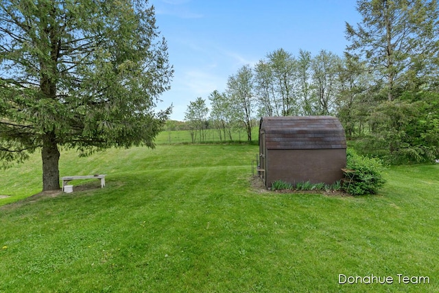 view of grassy yard with an outdoor structure and a storage shed