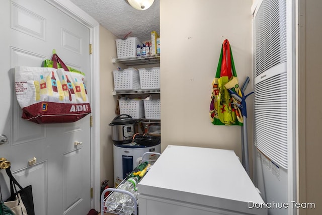 laundry area featuring a heating unit, a textured ceiling, and independent washer and dryer