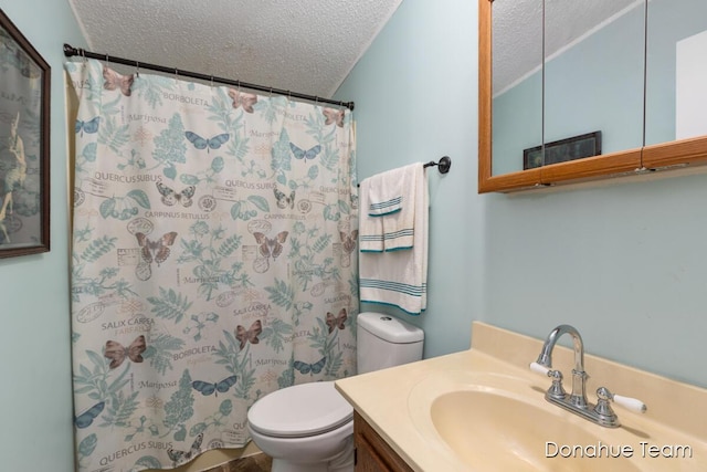 full bath featuring a textured ceiling, toilet, vanity, and curtained shower