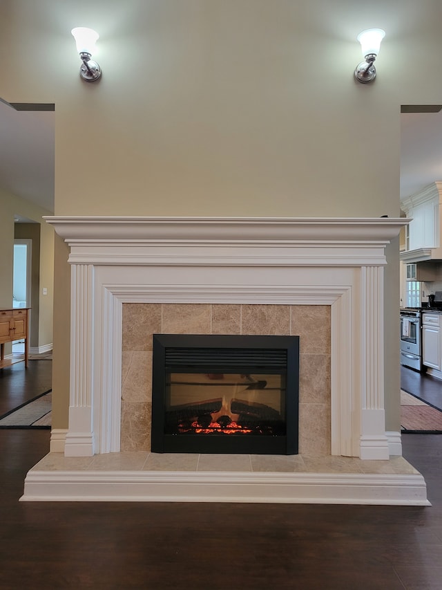 10726 Davisburg Rd, Davisburg, MI 48350 - detailed view of stainless steel range with gas cooktop, wood finished floors, a tile fireplace, and baseboards