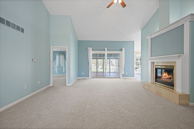 unfurnished living room featuring high vaulted ceiling, carpet flooring, ceiling fan, a tile fireplace, and baseboards