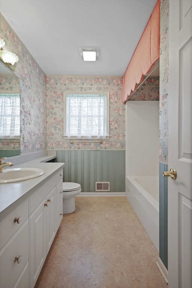 full bathroom with wallpapered walls, plenty of natural light, toilet, vanity, and a tub