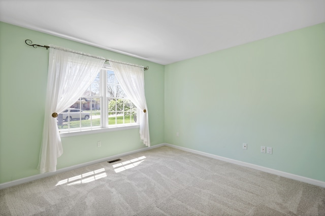 carpeted empty room featuring baseboards