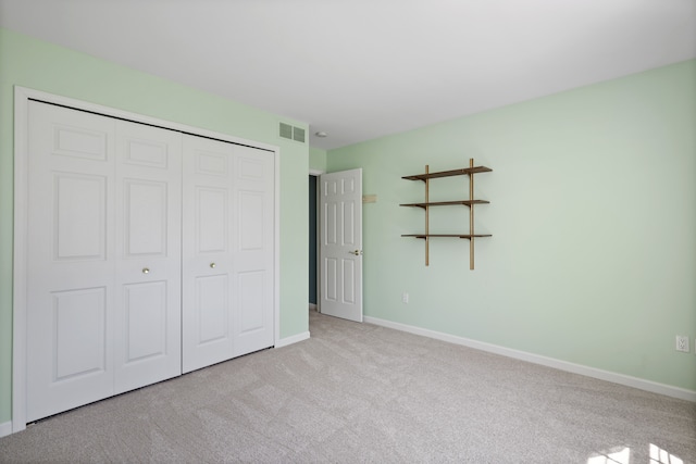 unfurnished bedroom with carpet, a closet, and baseboards