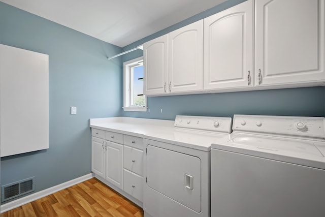 washroom featuring independent washer and dryer, light wood-style flooring, cabinet space, and baseboards