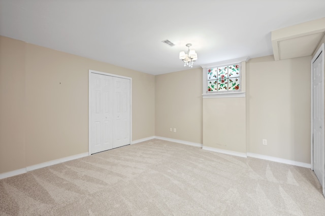 unfurnished bedroom featuring light carpet, a chandelier, and baseboards