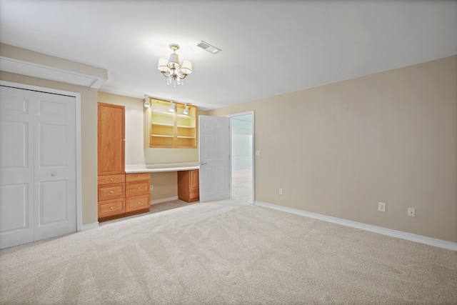 unfurnished bedroom with a chandelier, light colored carpet, baseboards, and a closet