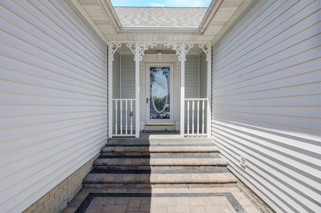 doorway to property featuring roof with shingles