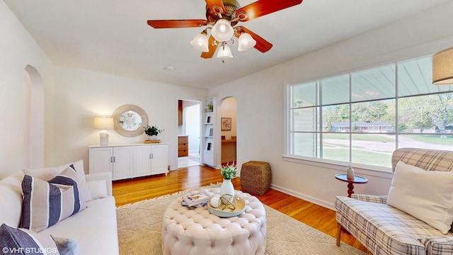 1200 Mohawk Ln, Saint Joseph, MI 49085 - living room with arched walkways, wood finished floors, ceiling fan, and baseboards