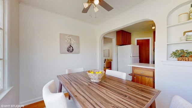 1200 Mohawk Ln, Saint Joseph, MI 49085 - dining room with arched walkways, a ceiling fan, ornamental molding, wood finished floors, and built in shelves