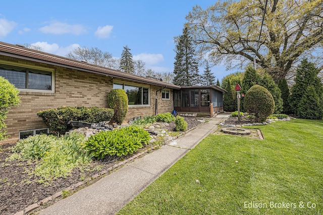 1657 W Kentview Dr NE, Grand Rapids, MI 49505 - view of front of property featuring a sunroom, brick siding, and a front lawn