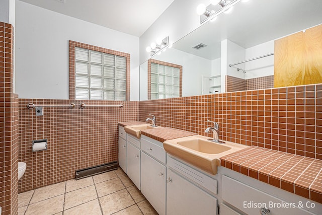 1657 W Kentview Dr NE, Grand Rapids, MI 49505 - full bath featuring tile walls, tile patterned flooring, a shower, toilet, and double vanity